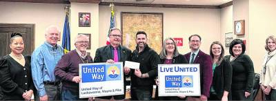 Pike County Commissioners Christa Caceres, Ron Schmalzle, and Matt Osterberg accept a donation from the United Way.