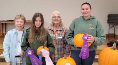 Master Gardener Mary Fenton, Truly Zablocky (Bethnay 4-H Club) with her Reserve Grand Champion pumpkin, Master Gardener Wanda Eisenhauer, and Channing Rutledge (Tri-Gal 4-H Club) with her Grand Champion Pumpkin.