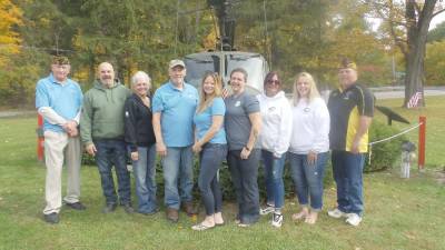 Some of the volunteers to distribute are pictured in front of the helicopter at the American Legion (from left): Jim Mulligan, first vice-president; Chris and Amy Racz; Frank Kalmbach, adjunct; Connie Harvey, Commander of American Legion Post 139; Brigid McHugh, Kilted Subs; Linda Reyes, Heart2ServeU; Tracy Grossi, Heart2ServU; and Greg Protsko, Commander of Mountain Laurel VFW Post 8612, who reached out to Sysco Central Pennsylvania food packaging to make the drive-up happen.(Photo by Frances Ruth Harris)