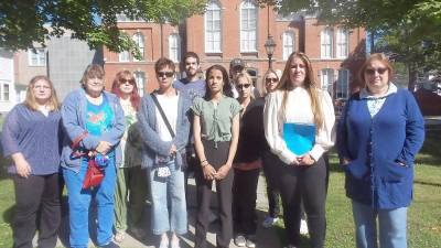 Eleven people (including one not pictured) turned out to the Pike County Courthouse on Wednesday morning to support Selina McGinnis (pictured in the green blouse, center), who is accusing humane society president Barry Heim of assaulting and sexually harassing her. Heim's wife, Janet Heim, pictured on the far right, said she is getting an order of protection against him (Photo by Frances Ruth Harris)