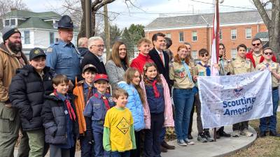 Scouts stand with Rep. Olsommer at flag raising.