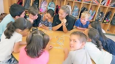 High school student helps out in elementary classroom