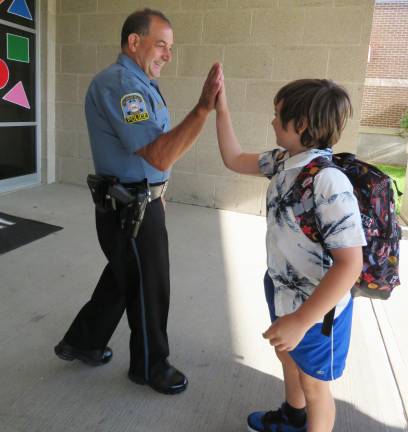 Officer Paul Cavallaro high-fives students as they enter Delaware Valley Elementary School on the first day of the 2026-27 school year.