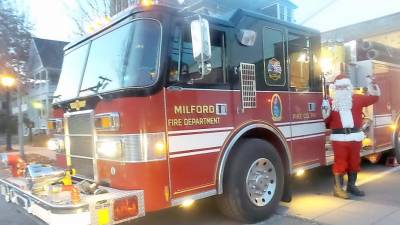 Santa with his sleigh bells just before jumping into his fire wagon sleigh to tour Milford. (Photo by Frances Ruth Harris)