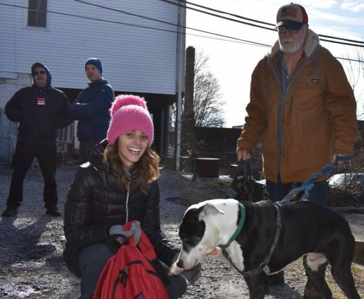Bill Epperly, who is legally blind, jolds the leash of his service dog, Panda, who is interested in the backpacking containing dog food that Marissa DeOliveira brought over.
