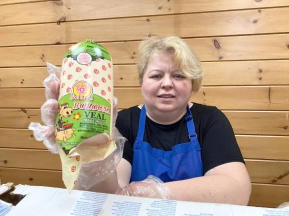 Tetyana (Tanya) Tserkovnyuk, owner of Food Carousel, holding one of the packaged delicacies she sells (bologna from veal).