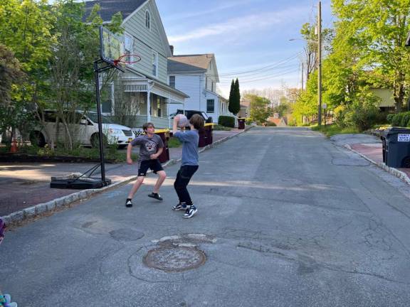 Liam Natale and Matthew Peacock playing basketball on John Street, Warwick. After a neighbor’s complaint, they have been warned that playing in the street is “contrary to local law.”