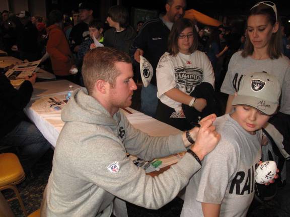 Matt McGloin, a former Oakland Raiders quarterback who grew up in Scranton, signs the shirt of a young fan. (Photo by Jerry Goldberg)