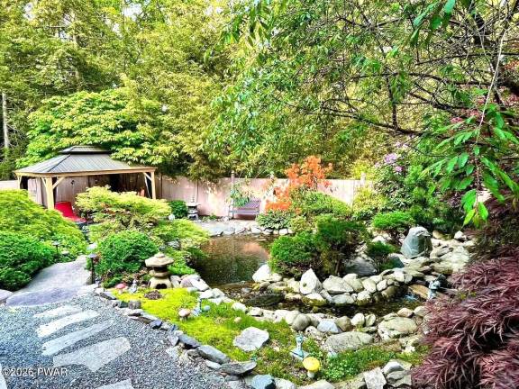 Home on private retreat has pond and waterfalls