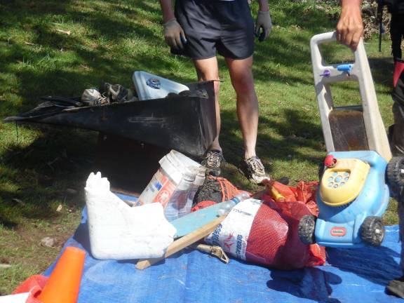 The cleanup crew pulled up this kids lawnmower and other trash, piled up at the Pond Eddy base. (Photo by Anya Tikka)