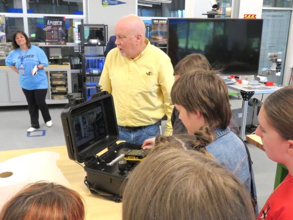 Dr. Sheehy showing the reporters the robot used for military and police applications. They were shown how to use the equipment!
