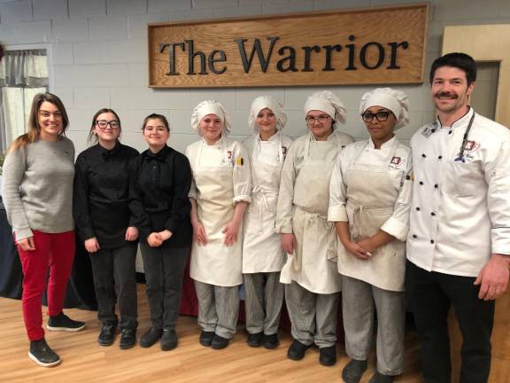 Rotary President Jamie Dykstra (left) poses with DVH culinary students and Chef Alex Niosi (right).