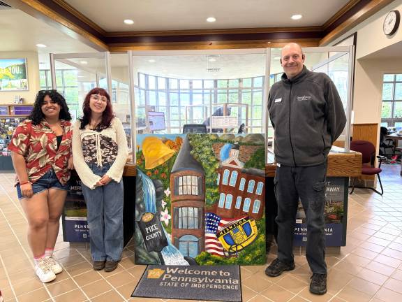 Mr. John Adams, Tourist Information Supervisor, along with student artists Gianna Rodriguez and Ruby Bailor with the commemorative painting at the Matamoras Welcome Center.