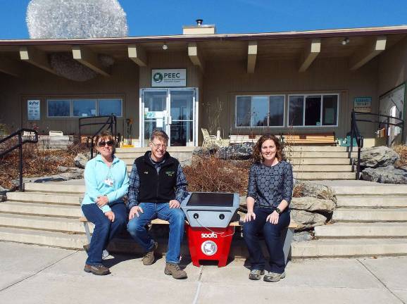Alana Roberts of PPL Electric Utilities (right) sits with PEEC’s Sheri Bone and Jeff Rosalsky (left and center) at the new solar cell phone charging station (Photo provided)