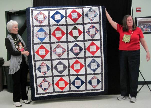 Carol Johnson (right) of Shohola, Pa., was recently installed as treasurer of the Warwick Valley Quilters Guild. She is pictured with Corinne Winters of Vernon, N.J., holding the "Valor Quilt."