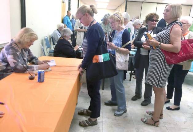 Anne Perry, a popular and prolific writer of historical detective fiction, signs books last year at the Milford Readers and Writers Festival, which has been cancelled for 2020.