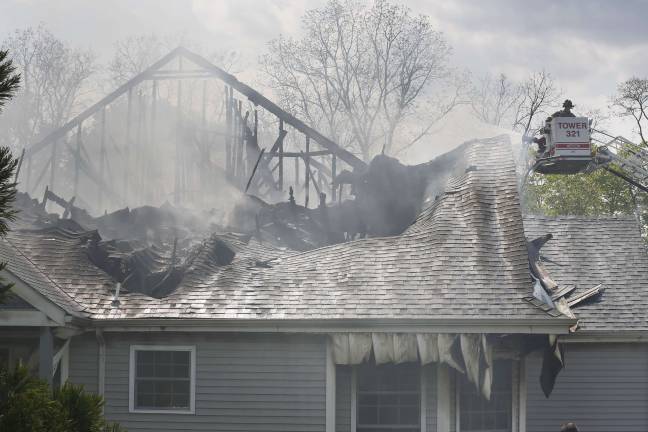 A fire department tower ladder directs a stream of water into the burning townhouse in Matamoras (Photo by Robert Breese)