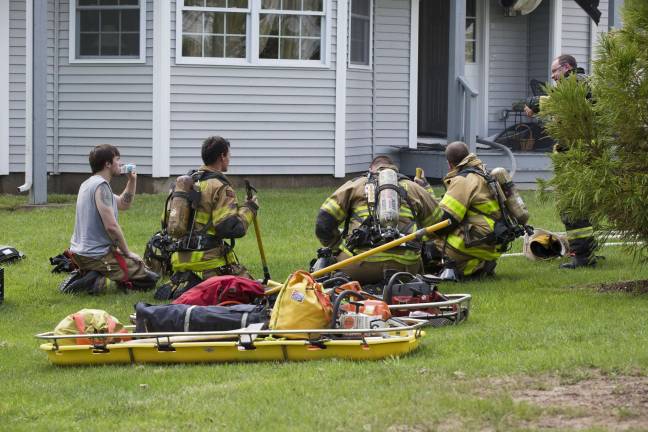 Firefighters try to stay cool in the 88 degree heat while fighting a townhouse fire in Matamoras (Photo by Robert Breese)