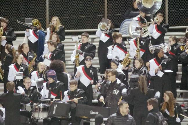 During the second quarter the Delaware Valley High School Marching Band play instruments and conversate while watching the game.