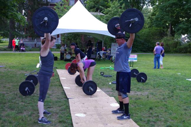 Participants pump iron while a band plays in the background.