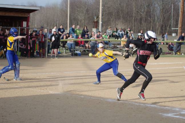 Valley View Cougar Jordan Seprosky about to throw as Delaware Valley Warrior MacKenna Powell runs towards first base.