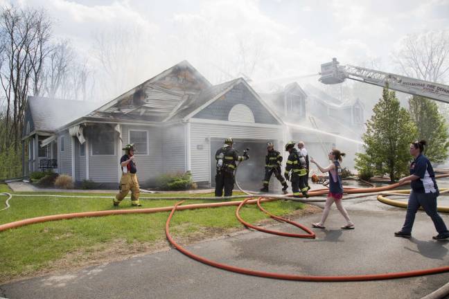 Firefighters from Orange, Pike, and Sussex counties extinguish a blaze that heavily damaged several townhouse units in Matamoras (Photo by Robert Breese)