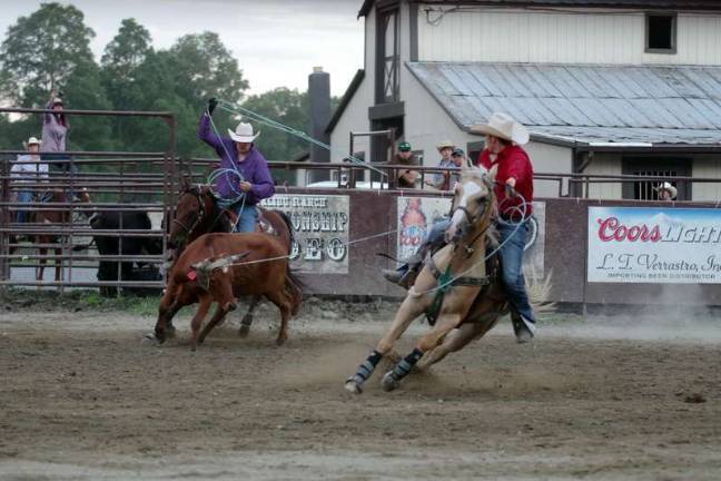 Cowboys show their steer roping skills.