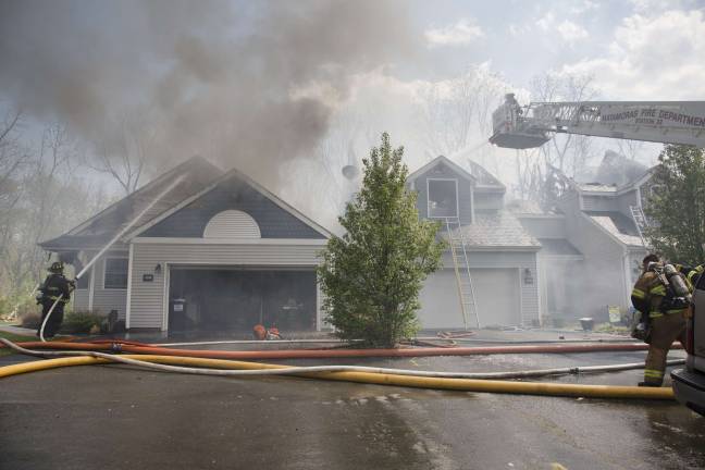 Firefighters from Orange, Pike, and Sussex counties extinguish a blaze that heavily damaged several townhouse units in Matamoras (Photo by Robert Breese)