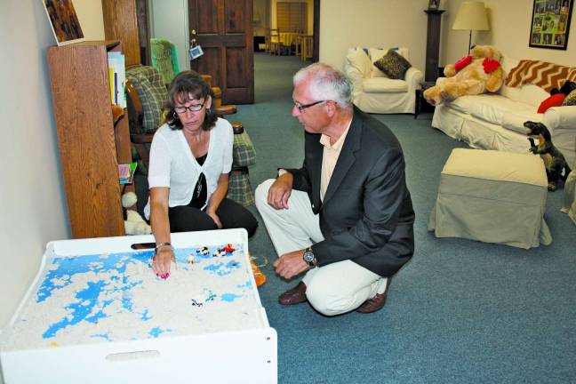 Diana Sebzda, Joseph T Quinlan Bereavement Director explains to Steve Bieganousky of Biggs Kids Foundation the use of &thorn;&Auml;&uacute;sand&thorn;&Auml;&ugrave; therapy and its value in helping to understand the grieving child as they play and often release hidden emotions. The Bereavement center, located at 61 Spring St, Newton holds children&thorn;&Auml;&ocirc;s grief art programs for any child who is suffering grief through the death of a loved one.