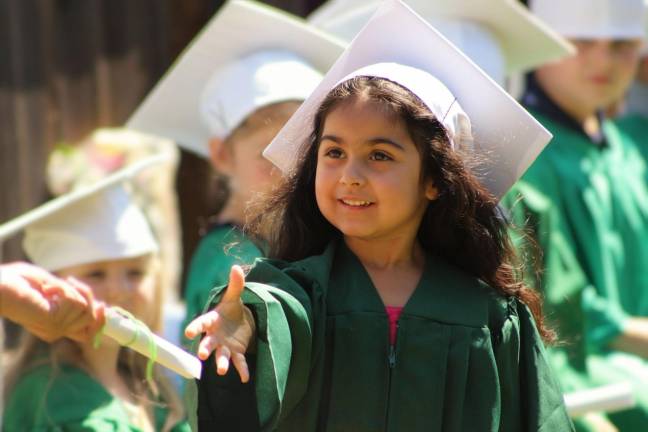 Green Trees Pre-K graduate Leilani receiving her diploma.