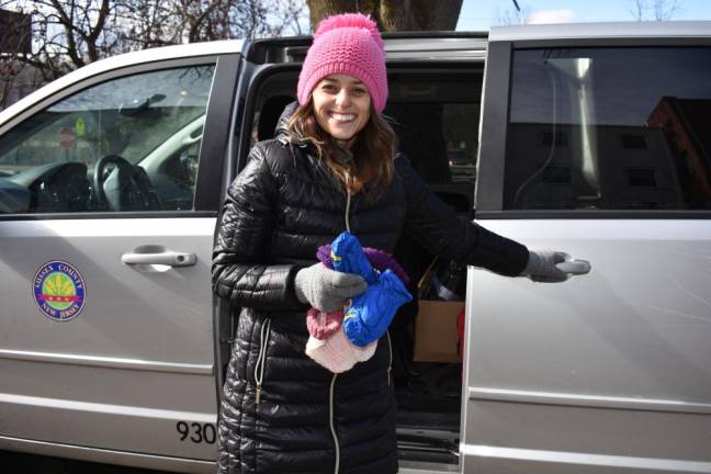Marissa DeOliveira grabs infant hats and mittens to offer to a new mom.