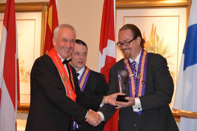 Chairman of the competition, Klaus Tritschler, Bailli D&#xe9;l&#xe9;gu&#xe9; of Germany and a member of the International Cha&#xee;ne&#x2019;s Conseil d'Administration, left, presents the first place trophy to 2012 Best Young Sommelier of the Year Christopher Bates. Looking on is runner-up Arnaud Bardary of Great Britain.