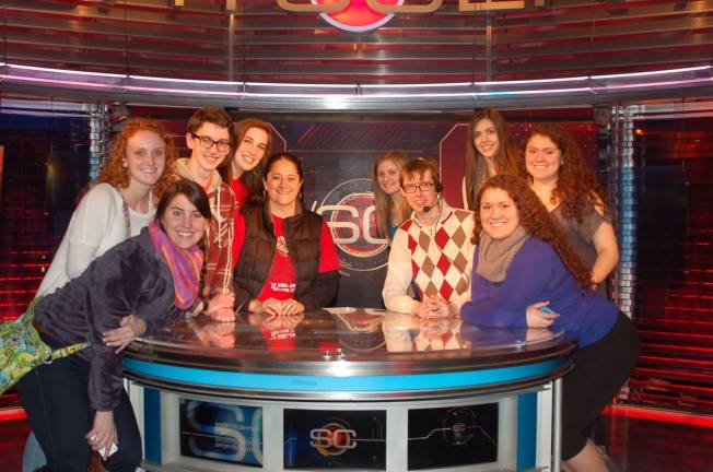 Pictured on the SportsCenter desk from left are: Erin McNeely, Anna Chamberlin, Nate King, Grace Farrell, DVHS Journalism Teacher Leslie Lordi, Jenny Wisniewski, ESPN Lead Studio Operator Ryan Balton, Alyssa Kelly, Marisa Balcarcel and Jessica Balcarcel.