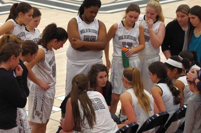 Delaware Valley Warriors girls varsity head basketball coach Lindsay Baker (kneeling) speaks during a break.