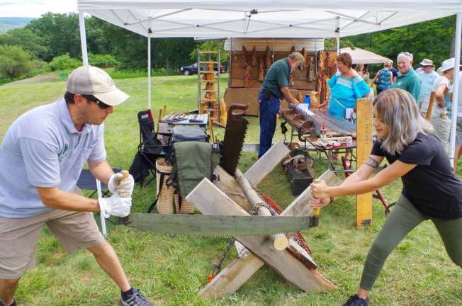 Forester Jeremy Caggiano (right) works with a guest while demonstrating a double-handle cross-cut saw.