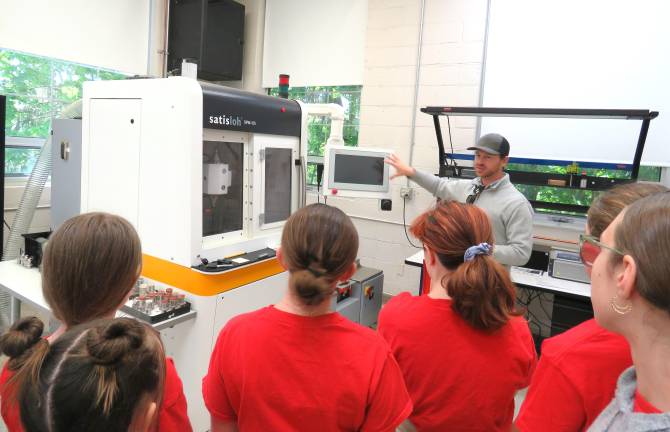 DVE-News/TV reporters looking at the optic machinery with Mr. Jack Stafford.