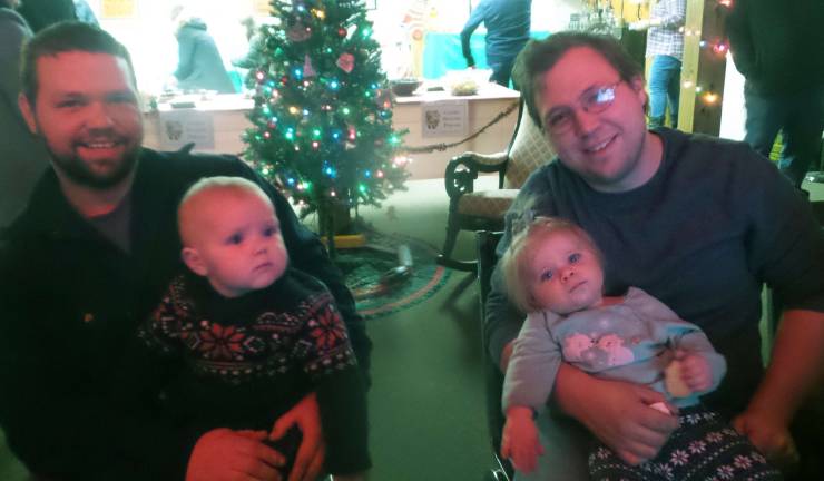 Brothers Matt and Noah Martin hold daughters Danielle and Arielle as they watch children’s classics in the Foundation Room (Photo by Frances Ruth Harris)