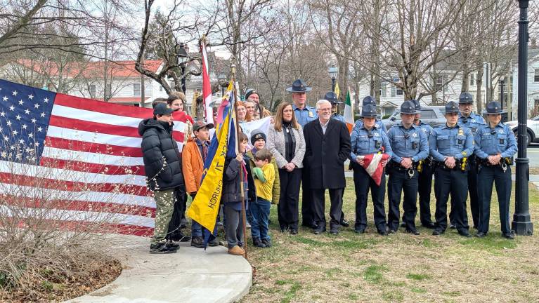 Scouts stand with County Sheriff’s Department at flag raising.