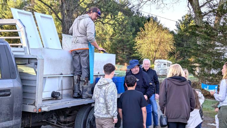 Volunteers help stock the pond ahead of the Fishing Derby.
