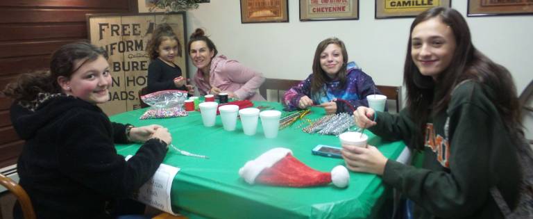 Elizabeth Diety, Carla Randazzo, Maria Randazzo, Chelsea Burse, and Dionne Miceli made jewelry and delightful head pieces at the crafts table. (Photo by Frances Ruth Harris)
