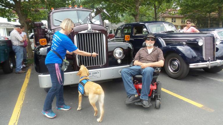 Benni learns to follow directions and take a position as Chrisanne Cubby points to a spot near Frank Fellippello in Key Food parking lot during the Antique Car Show (Photo by Frances Ruth Harris)