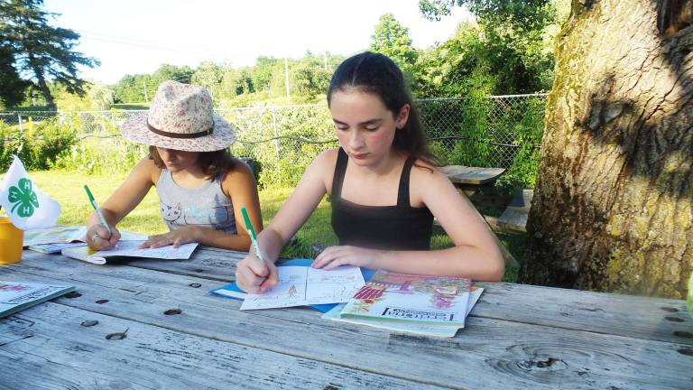 Hannah Williams and Eva Nienstadt complete the lesson using a seed catalog and their work sheet (Photo by Frances Ruth Harris)