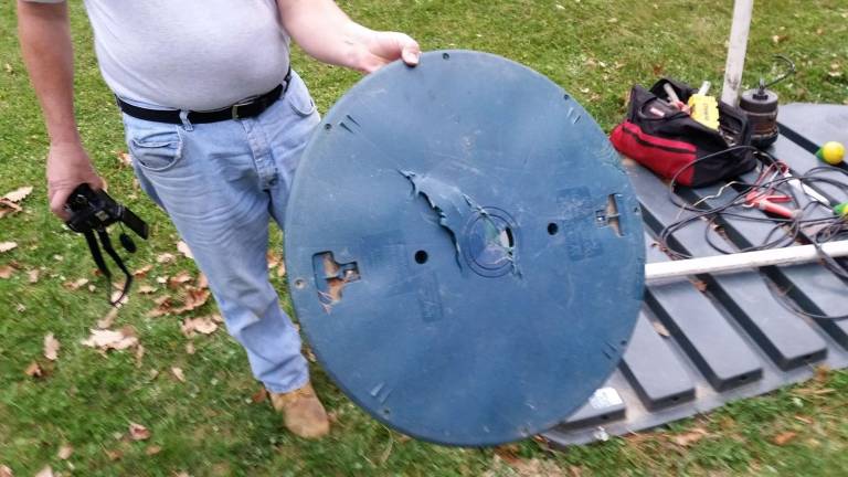Dingman code enforcement officer Chris Wood with a bear-chewed lid (Photo by Anya Tikka)