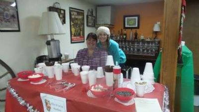 The hot cocoa station was a popular stop on a chilly evening. Eryn Kelly and her niece Kayla Kelly offered marshmallows, chocolate pieces, and whipping cream. Each child and many adults too created their own "cocoa happiness" moment. (Photo by Frances Ruth Harris)