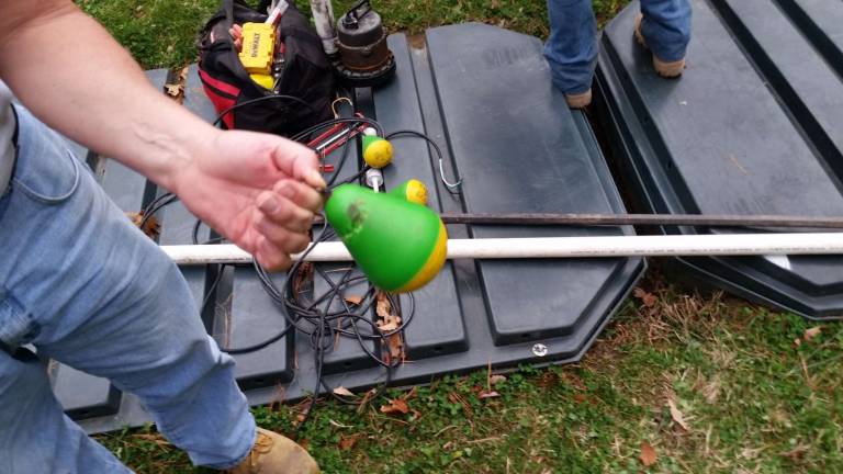Dingman code enforcement officer Chris Wood shows a chewed float, with set off the trouble alarm at one house (Photo by Anya Tikka)