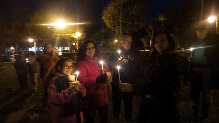Lighted candles brought the vigil to life as participants stood in silence honoring survivors of domestic abuse and those forcibly silenced. (Photo by Frances Ruth Harris)