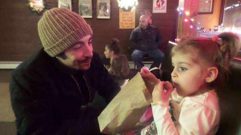 Gerard Gary with daughter Anastasia, who munched donuts while watching classic films and visiting with Santa (Photo by Frances Ruth Harris)