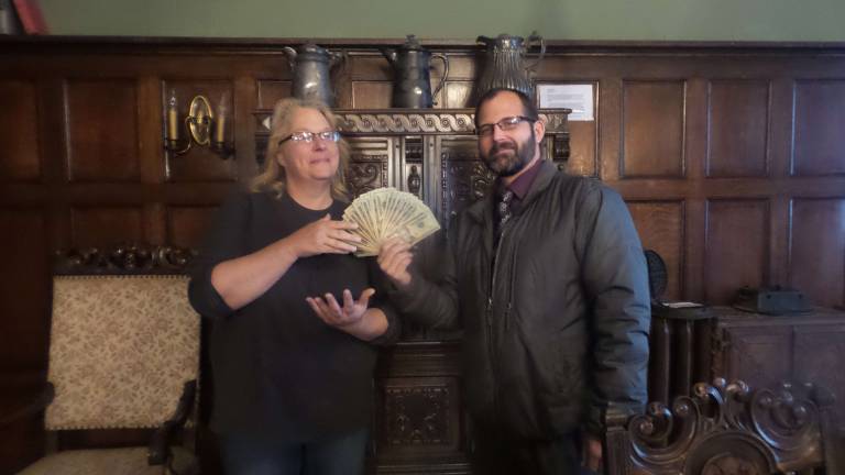 Lori Strelecki, director and curator of the Columns, accepts proceeds from Tim Kelly for his recent ghost tours (Photo by Frances Ruth Harris)