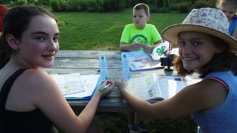 Master Gardener Angela Williams gave each young gardener a book mark to keep their place in their seed catalogue (Photo by Frances Ruth Harris)