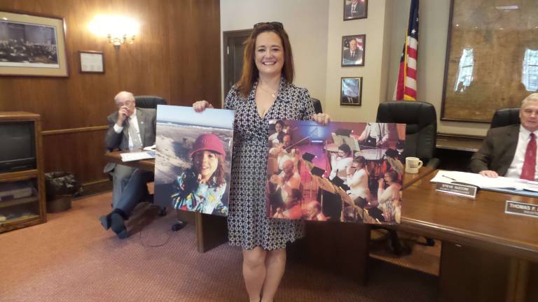 Maggie O'Brien of Make-A-Wish holds pictures of local children who have had their wishes granted. (Photo by Frances Ruth Harris)